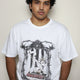 White oversized t-shirt worn by a model, featuring the “Agnus Dei” design: a lamb with seven eyes and horns seated on the Book with Seven Seals, framed by ornate gothic elements — part of your grunge Indian Christian streetwear line.